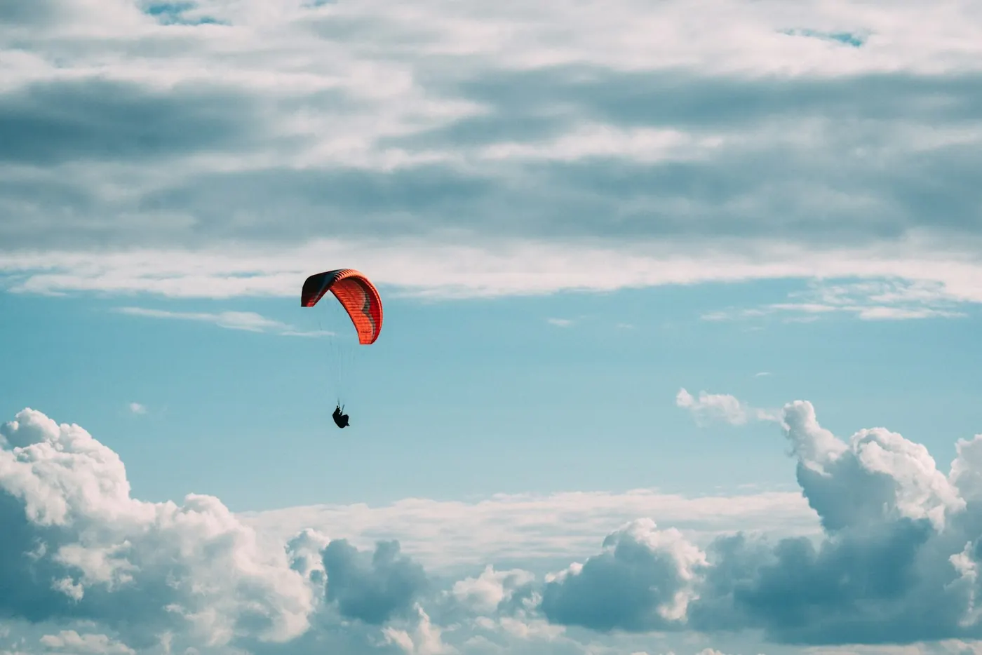 A paraglider above the clouds