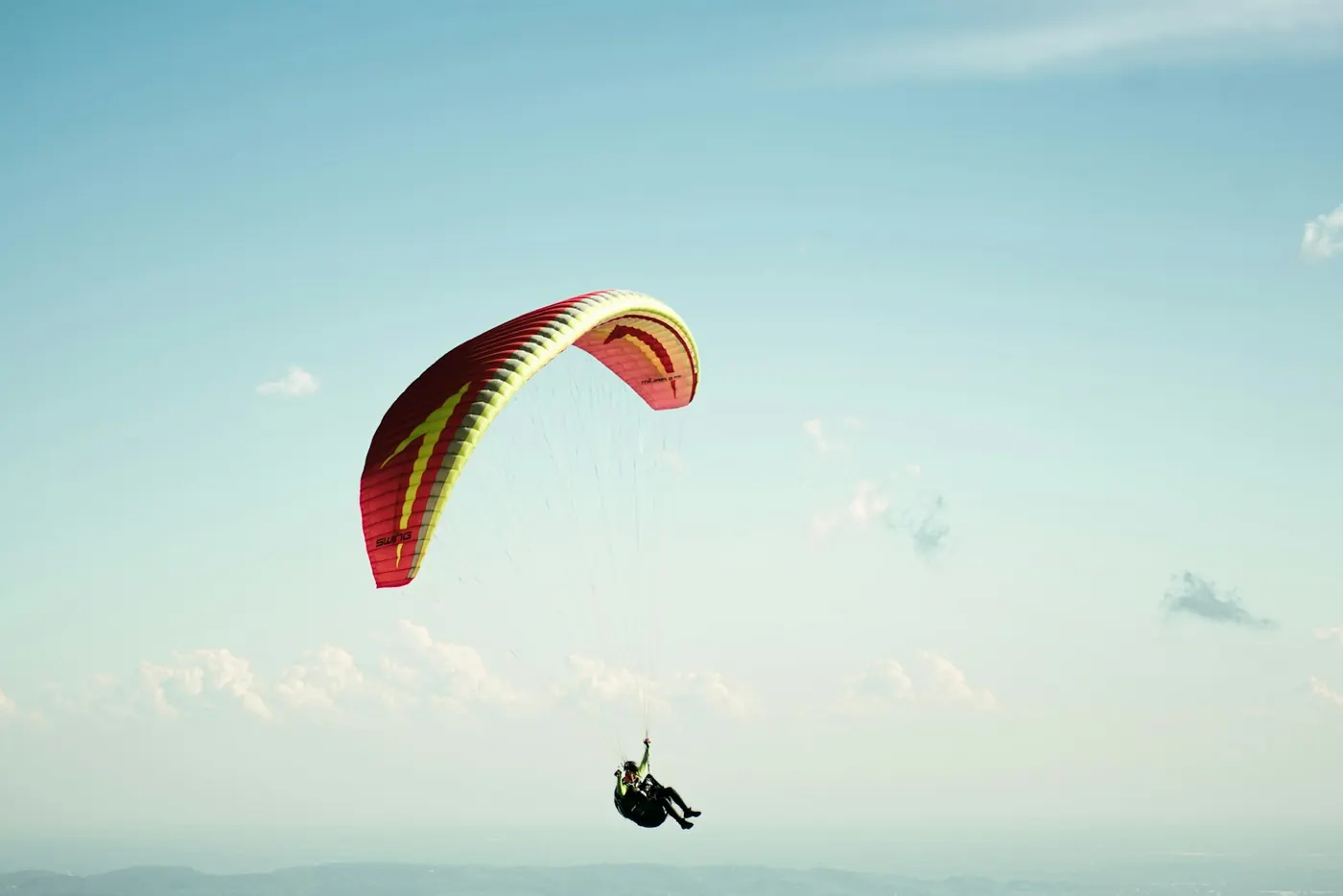A paraglider in a clear blue sky