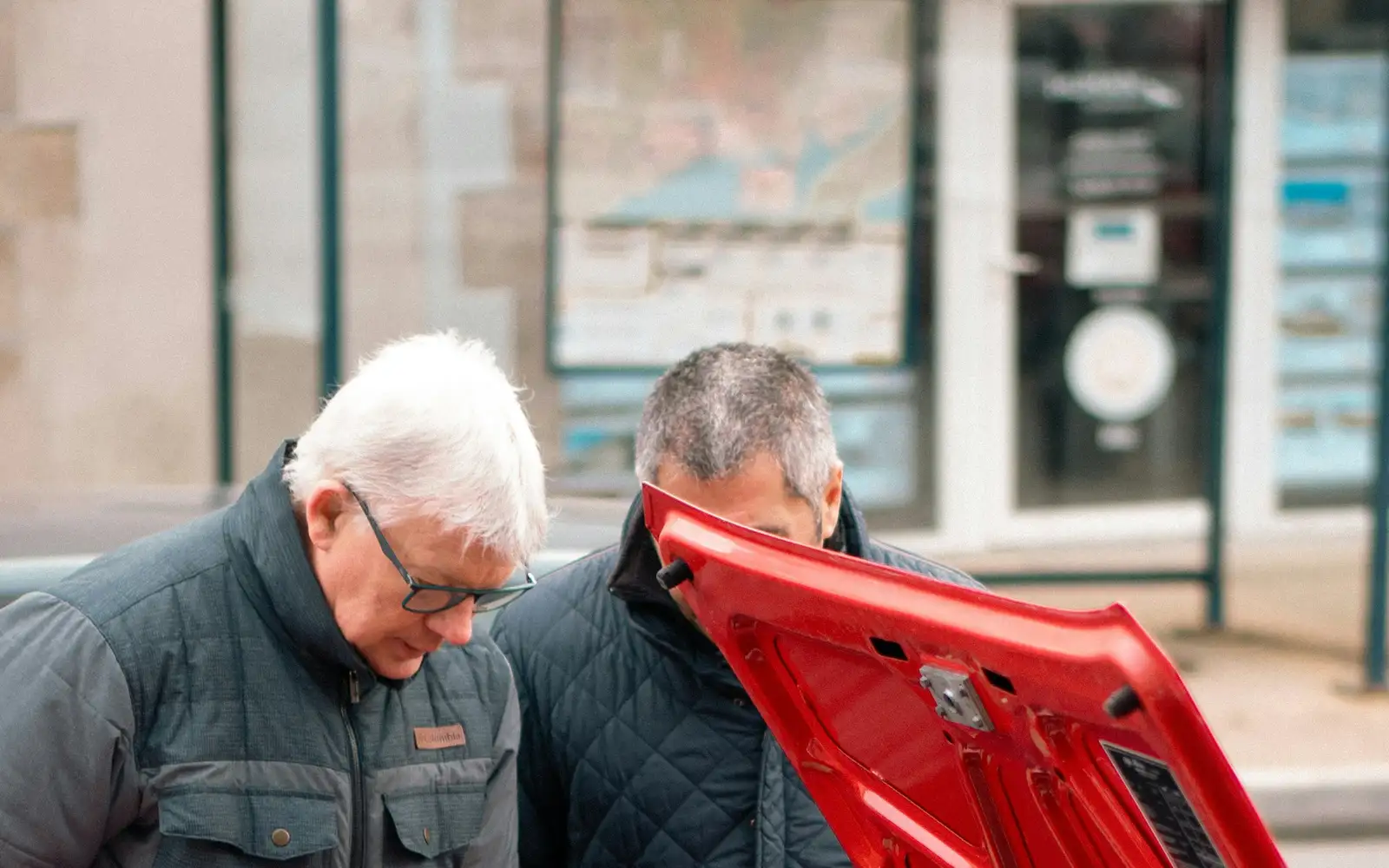 Two people inspecting a car engine