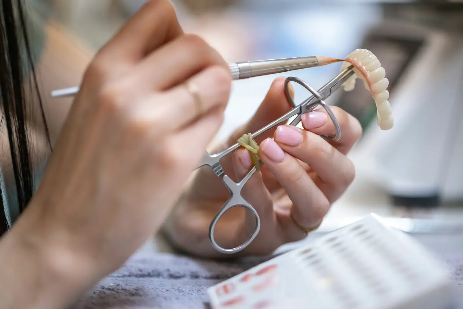 Hands crafting a dental prosthesis