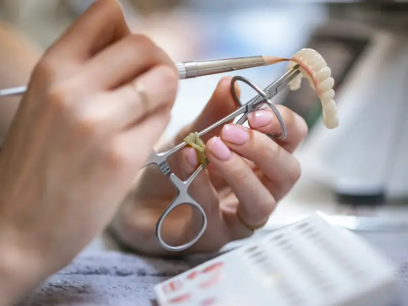 Hands finishing a dental restoration