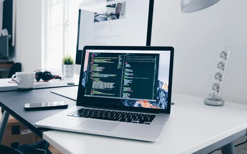 A laptop with code on a bright desk