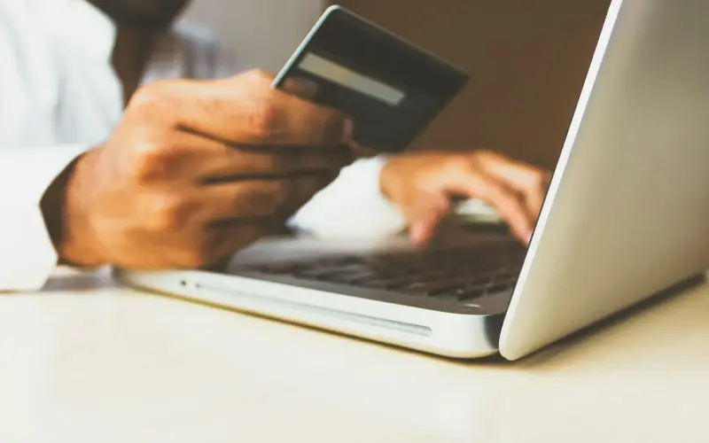 Paying online with a card at a laptop