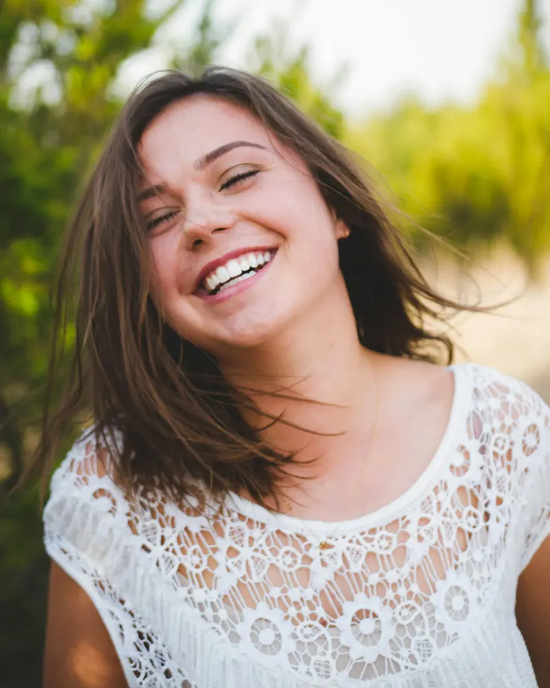 A woman laughing with a bright, confident smile