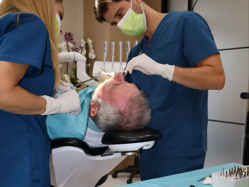 Dr. Sremčević and his assistant treating a patient in his practice in Kraljevo